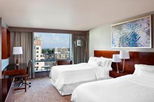 um quarto de hotel com duas camas e uma grande janela em The Westin Arlington em Arlington