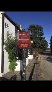 een rood bord aan de zijkant van een gebouw bij The Shandwick Inn in Tain