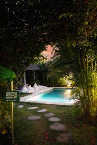 a swimming pool with stepping stones next to a tree at Bingin Bienvenue Guest House in Uluwatu