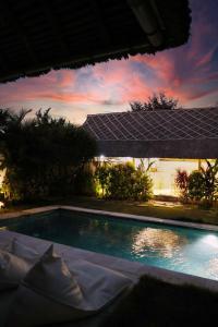 a swimming pool with solar panels on top of it at Bingin Bienvenue Guest House in Uluwatu