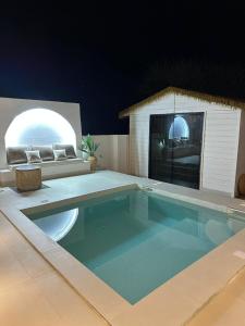 une maison avec une piscine et une chambre avec un canapé dans l'établissement Wadi Bani Khalid - Al Joud Green Hostel 2, à Dawwah