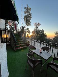 a patio with a table and chairs on a balcony at Ortus - Murree Hills in Murree