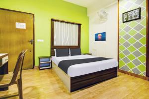 1 dormitorio con cama, escritorio y silla en Super Hotel O Porvorim Near Mall De Goa, en Panaji