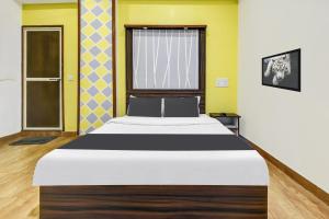 Cama grande en habitación con paredes amarillas en Super Hotel O Porvorim Near Mall De Goa, en Panaji