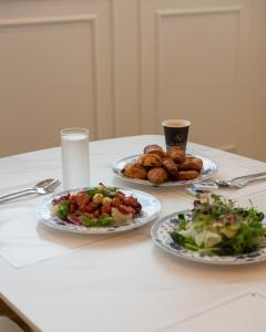 una mesa con dos platos de comida y una ensalada en Gunsan Stay Tourist Hotel, en Gunsan