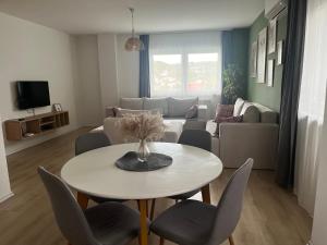 a living room with a table and chairs and a couch at Apartment Mejdan in Tuzla