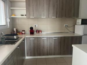 a kitchen with wooden cabinets and a white refrigerator at Apartment Mejdan in Tuzla