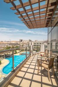 einen Balkon mit Stühlen und Poolblick in der Unterkunft Steigenberger Pyramids Cairo in Kairo