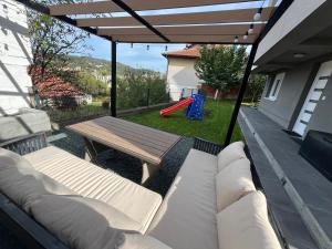 a patio with a bench and a table and a playground at Apartment Mejdan in Tuzla