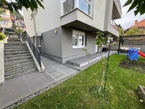 a house with stairs and a grass yard at Apartment Mejdan in Tuzla