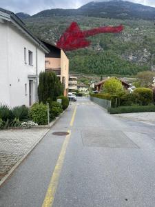 una calle vacía con un objeto rojo volando sobre un edificio en Glishorn Blick, en Brig