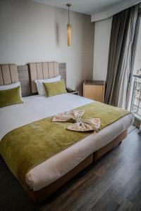 een slaapkamer met een groot bed met 2 slippers erop bij AZ hôtel des arts in Rabat