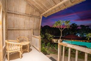 um alpendre com uma mesa e cadeiras e uma piscina em Wijaya Cottage Nusa Penida em Nusa Penida