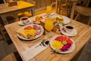 uma mesa de madeira coberta com pratos de comida e bebidas em Wijaya Cottage Nusa Penida em Nusa Penida