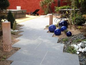 een stenen loopbrug met blauwe ballen in een tuin bij Le Corrigot in Pierry