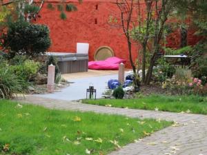 een tuin met een rode muur en een bed bij Le Corrigot in Pierry