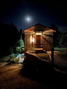 una casa in pietra con una porta illuminata di notte di Quinta dos Mascarenhas Nature House a Oliveira do Hospital