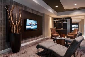 a living room with a couch and chairs and a tv at Courtyard Novato Marin/Sonoma in Novato