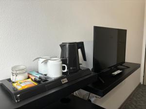 a black table with a coffee maker on it at Hotel Pangea in Telč