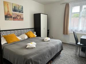 a bedroom with a bed with towels on it at Hotel Pangea in Telč