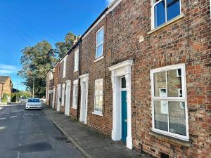 een bakstenen gebouw met een auto op straat bij Comfy Home within City Wall, 10 mins Walk to Centre, Attractions & Railway Station in York