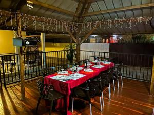 a long table with red table cloth and chairs in a room at Résidence Le Tali in Libreville