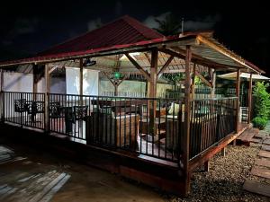 un gazebo in legno con una recinzione intorno di Résidence Le Tali a Libreville