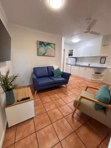 un soggiorno con divano blu e una cucina di Mackay Seabreeze Apartments a Mackay