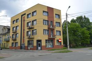 een geel gebouw op de hoek van een straat bij Kamienica - mieszkanie dwupokojowe in Skarżysko-Kamienna