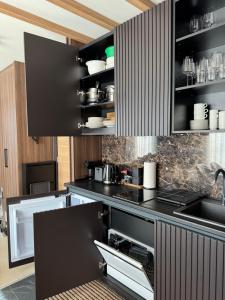 une cuisine avec des armoires noires et un comptoir noir dans l'établissement Woodside Apartment 431, Kopaonik - One separate bedroom 35m2- FREE Parking & SPA, à Kopaonik