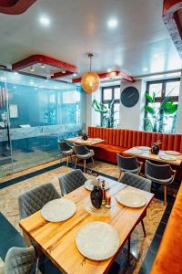 a restaurant with tables and chairs and a red couch at Villa & Restaurant Levoslav House in Sibiu