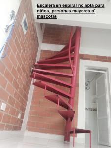 eine rote Wendeltreppe in einem Backsteingebäude in der Unterkunft A diez minutos del aeropuerto in Palmira