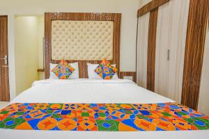 a bedroom with a bed with a colorful comforter at FabHotel Darshan Adobe - Nr Bus stand in Coimbatore