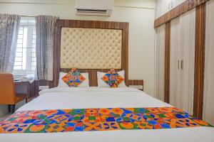 a bedroom with a large bed with a colorful comforter at FabHotel Darshan Adobe - Nr Bus stand in Coimbatore