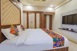 a bedroom with a bed and a flat screen tv at FabHotel Darshan Adobe - Nr Bus stand in Coimbatore