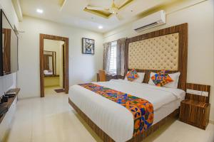 a bedroom with a large bed and a television at FabHotel Darshan Adobe - Nr Bus stand in Coimbatore