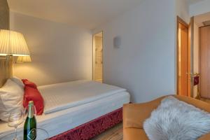 een slaapkamer met een bed, een stoel en een tafel bij Hotel Sporting Trento in Trento