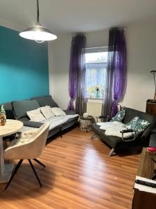 ein Wohnzimmer mit einem Sofa und einem Tisch in der Unterkunft Ferienwohnung HAPPYHOME Bahnhofnah gemütlich familiär in Arnstadt