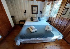 a bedroom with a large bed with towels on it at Ruma Andina by DOT Cabana in Villa La Angostura