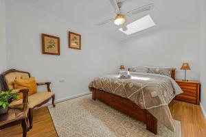 ein Schlafzimmer mit einem Bett und einem Stuhl in der Unterkunft Guesthouse in W Gosford Centre in Gosford