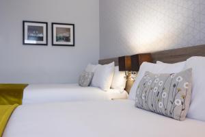 2 letti in camera d'albergo con lenzuola e cuscini bianchi di Crowne Plaza Liverpool City Centre, an IHG Hotel a Liverpool