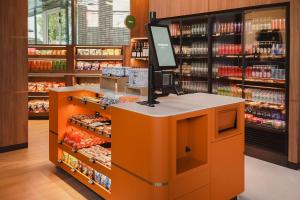 een levensmiddelenwinkel met een oranje aanrecht en planken met voedsel bij DoubleTree by Hilton Amsterdam Centraal Station in Amsterdam