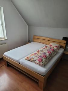 - un lit dans une petite pièce ornée de fleurs dans l'établissement Obere Etage des Hauses, à Enns