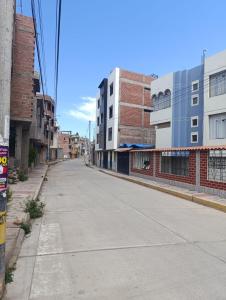 an empty street in a city with buildings at casa SKALA in Puno