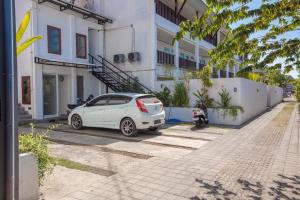 een witte auto geparkeerd voor een gebouw bij Braban Sari Bali in Seminyak