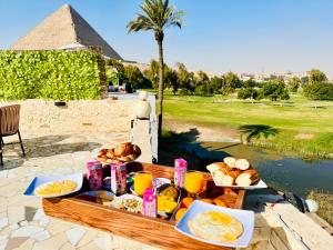 Golf Pyramids View في القاهرة: طاولة طعام الافطار و هرم في الخلفية