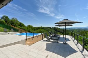 een patio met een parasol en een zwembad bij Kuća za odmor Freya in Krapinske Toplice