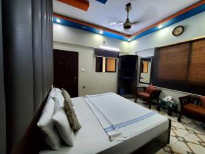 a bedroom with a bed and a living room at Diplomat Inn Hotel in Karachi