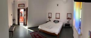 um quarto com uma cama num quarto branco em Hari Niwas Guest House em Udaipur