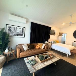 ein Wohnzimmer mit einem Sofa und einem Bett in der Unterkunft Studio 34 - Nelson Bay in Nelson Bay